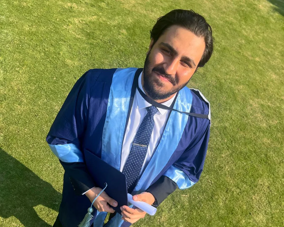 Zulqarnain in convocation gown holding his degree at FAST-NUCES graduation