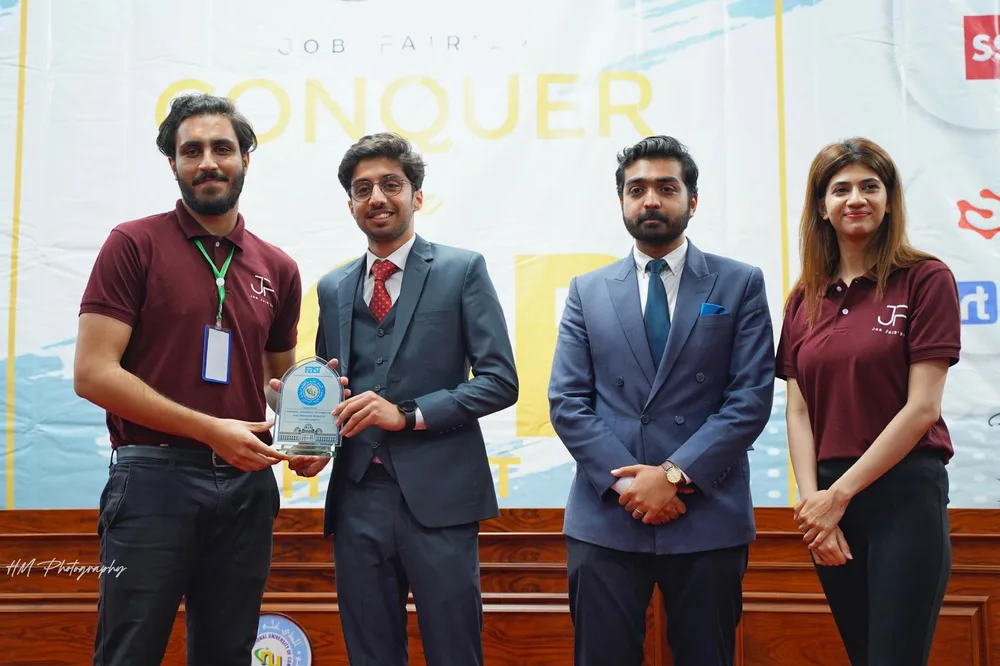 Receiving an award shield on stage at the FAST-NUCES job fair